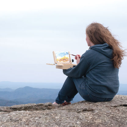 Artist Painting with ThumBox on a Mountaintop